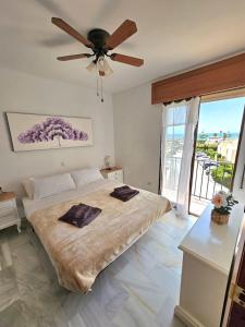 a bedroom with a large bed with a ceiling fan at Apartamento SEA VIEW Celeste Costa del sol Playa Chapparal in Mijas Costa