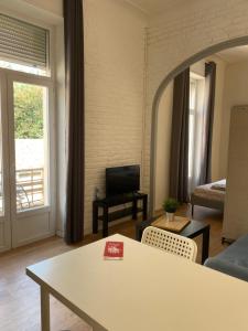a living room with a table and a room with a window at LA MAISON D'ANTONIN 2 in Nîmes