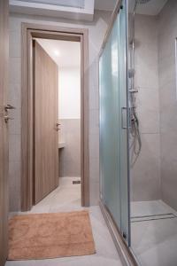 a bathroom with a shower and a glass door at Piraeus port 1 bedroom 2 persons apartmet by MPS in Piraeus