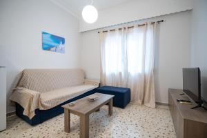 a living room with a couch and a table and a tv at Piraeus port 1 bedroom 2 persons apartmet by MPS in Piraeus