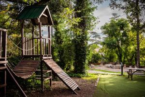 un parque infantil de madera con un tobogán en un parque en Los Espinillos Hotel y Spa en Villa Carlos Paz