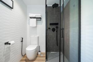 uma casa de banho com um WC e uma cabina de duche em vidro. em Casa Talay 4 Bedroom Pool Villa - Meia Praia Beach, Lagos em Lagos