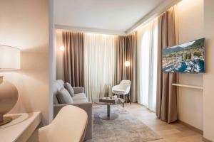 a living room with a couch and a tv at Bellerive Lifestyle Hotel in Salò