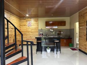 cocina con encimera y taburetes en una habitación en Ulina Villa Segitiga Berastagi en Berastagi