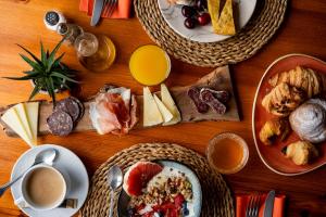 a wooden table with plates of food and cups of coffee at Hotel Sant Joan in Palamós