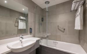 W łazience znajduje się umywalka, prysznic i wanna. w obiekcie Maldron Hotel Belfast International Airport w mieście Aldergrove