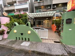 zielona rzeźba kota siedząca na boku budynku w obiekcie Hong Ting Xuan w mieście Taidong