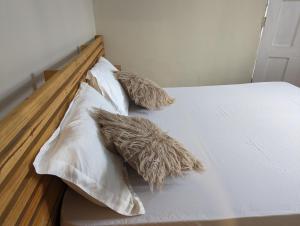 2 almohadas en una cama con sábanas blancas en Elizabeth Home en Arusha