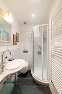 a white bathroom with a shower and a sink at Agriturismo Castel Dho in Castel Vittorio