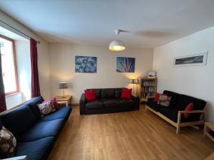 ein Wohnzimmer mit zwei schwarzen Sofas in der Unterkunft Townhouse The Granary Bourg d’Oisans in Le Bourg-dʼOisans