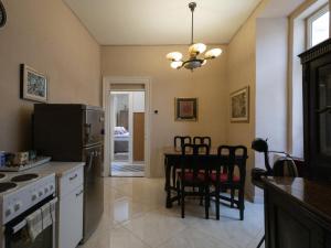 cocina con mesa, sillas y nevera en Garden Apartment Marina, en Dubrovnik