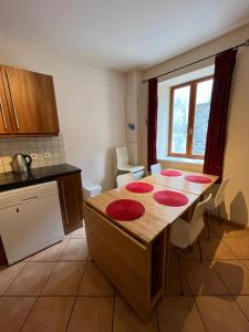 eine Küche mit einem Holztisch mit roten Platten darauf in der Unterkunft Townhouse The Granary Bourg d’Oisans in Le Bourg-dʼOisans