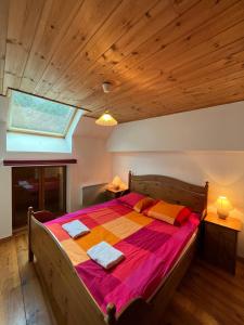 ein Schlafzimmer mit einem großen Bett und einer Holzdecke in der Unterkunft Townhouse The Granary Bourg d’Oisans in Le Bourg-dʼOisans