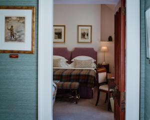 a bedroom with a bed and a table and chairs at Links House at Royal Dornoch in Dornoch