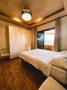 Un dormitorio con una cama grande y una lámpara de araña. en Delia's Guest House en Isla de Mactán