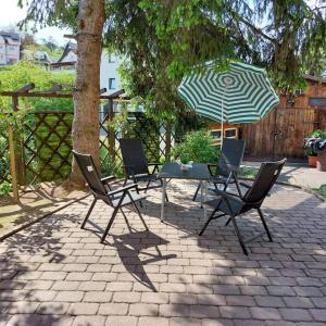 un patio con mesa, sillas y sombrilla en Ferienwohnung Hanna, 