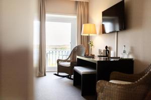 una camera d'albergo con scrivania, sedie e finestra di Hotel Dieksee - Collection by Ligula a Malente