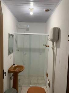ein Bad mit einer Dusche, einem WC und einem Waschbecken in der Unterkunft HOSTEL PACÍFICO in Tramandaí