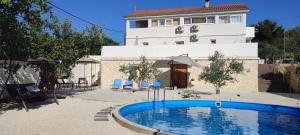 una piscina frente a un edificio en Apartments Villa Mihaela en Banj