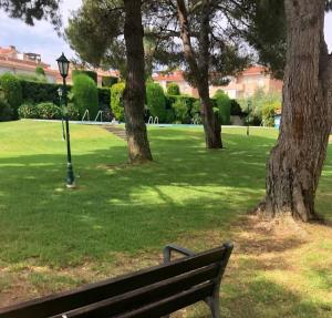 a park with a bench and trees and a street light at Apartamento en Platja Sant Pol S'agaro con pisicina y jardin (playa - centro) in Sant Feliu de Guixols