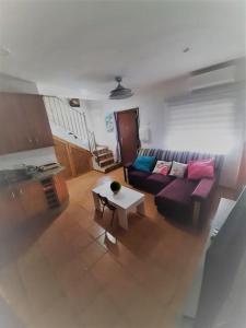 uma sala de estar com um sofá roxo e uma mesa em Casa mis Nietas em San José