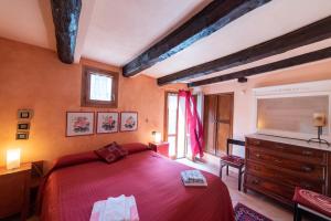 a bedroom with a large red bed and a dresser at Agriturismo Castel Dho in Castel Vittorio