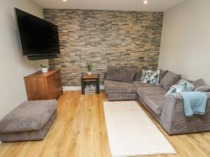 a living room with a couch and a flat screen tv at Fir Tree Cottage in Caernarfon