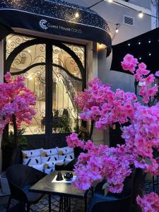uma mesa com flores cor-de-rosa em frente a um restaurante em Boutique Guest House Coco em Plovdiv