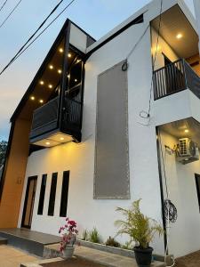 un edificio blanco con balcón y flores. en Villa Aruki Bukittinggi, en Bukittinggi