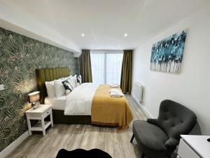a bedroom with a bed and a chair in it at The Atlantis - Tower Apartments in Great Yarmouth