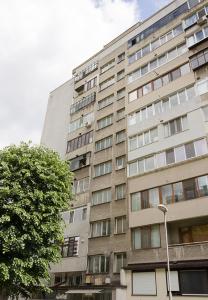 Un edificio alto con un albero davanti di Chayka Charm Cozy 1BD Apartment in Varna a Varna