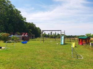 a park with a swing set in the grass at Les Chalets du Quignon in Autry-le-Châtel