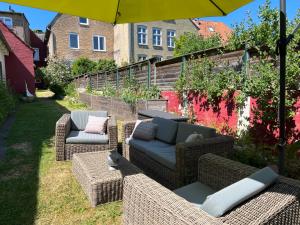 a patio with couches and chairs under an umbrella at Ferienwohnung - Unterm Dach in Schleswig