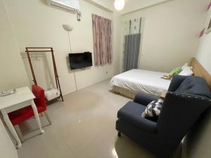 mały pokój z łóżkiem i niebieskim krzesłem w obiekcie Hong Ting Xuan w mieście Taidong