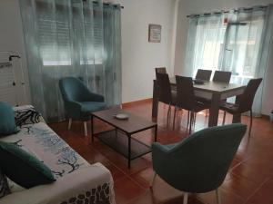 a living room with a table and chairs at Apartamento Bella Vista São Martinho do Porto in São Martinho do Porto