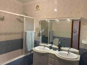 a bathroom with two sinks and a large mirror at Apartamento Bella Vista São Martinho do Porto in São Martinho do Porto +17 photos