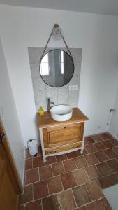 a bathroom with a sink and a mirror at Petite maison de campagne in La Bazoge +4 photos