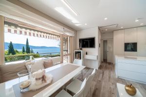 ein Esszimmer mit einem Tisch und einem großen Fenster in der Unterkunft Apartment Wieser Garda Lake in Gargnano