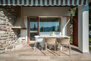eine Terrasse mit einem weißen Tisch und Stühlen in der Unterkunft Apartment Wieser Garda Lake in Gargnano