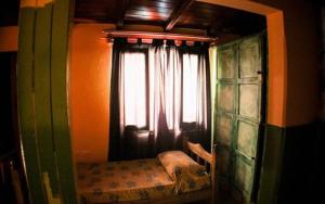 1 dormitorio con ventana y 1 cama con cortinas en Hostel Trotamundos en San Rafael