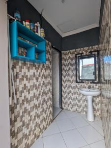 Elizabeth Home في أروشا: حمام مع حوض ونافذة