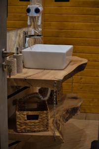 lavabo blanco en una encimera de madera en el baño en Cabana AFrame Olanesti en Băile Olăneşti