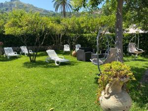 a yard with a group of chairs and a swing at Villa Sofia in Parghelia