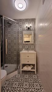 y baño con ducha y lavamanos. en Apartament nad zalewem 217, en Serock
