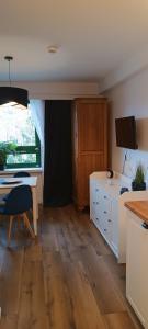 a kitchen with a table and a desk in a room at Apartament nad zalewem 217 in Serock