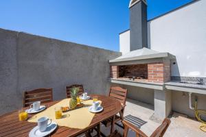 a table and chairs on a patio with a fireplace at Domus Alba Apartments in Pula