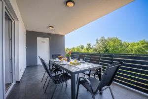 a dining room with a table and chairs on a balcony at Domus Alba Apartments in Pula