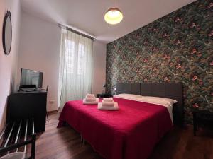 a bedroom with a red bed with towels on it at Hotel Brenta in Parma