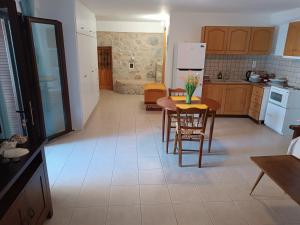 eine Küche mit einem Tisch und Stühlen sowie einem Kühlschrank in der Unterkunft Mani home in Neon Oitilon