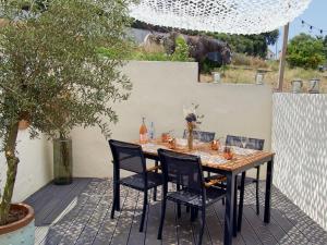 una mesa de madera y sillas en un patio en Résidence de la Tour en Piana